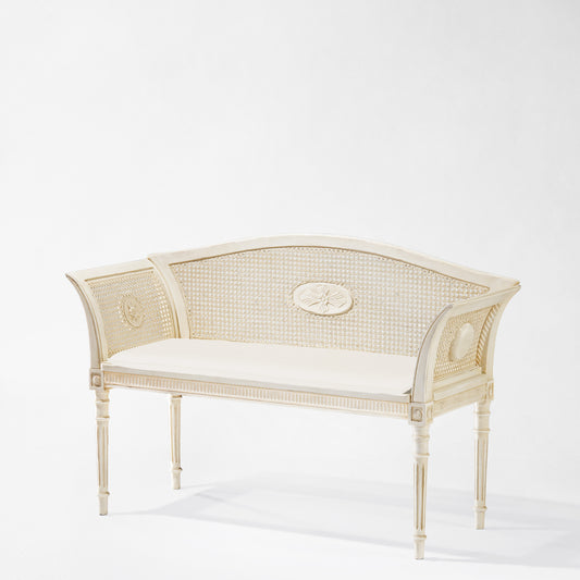 Antique white wood bench with cane back.