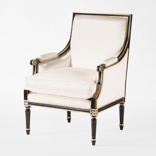 Black armchair with silver accents and cream fabric.