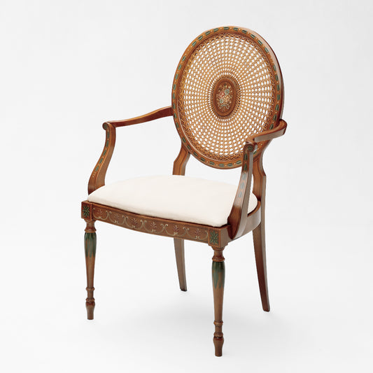 Brown wood armchair with cane back and cream fabric.