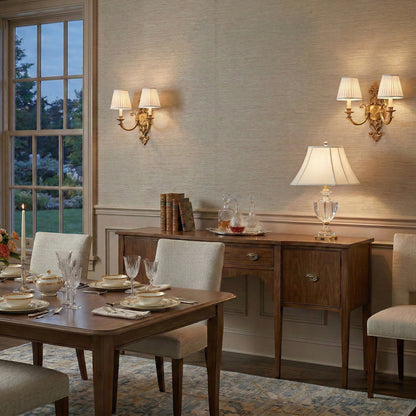 An Antique Brass sconce with pleated white shades.