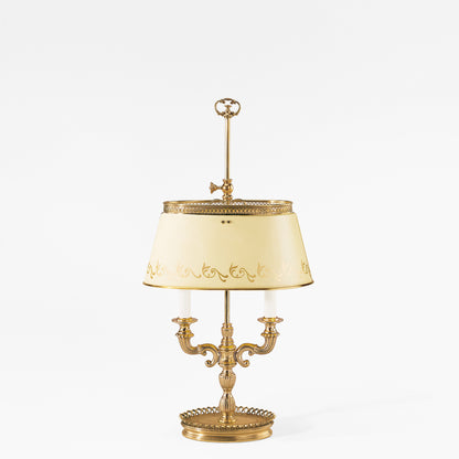 Antique brass bouillotte lamp with white lamp shade.