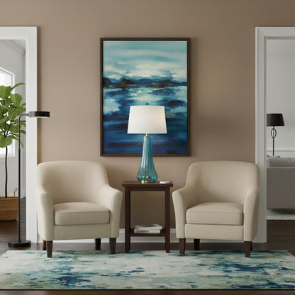 A blue Murano Glass Lamp in a living room surrounded by arm chairs.