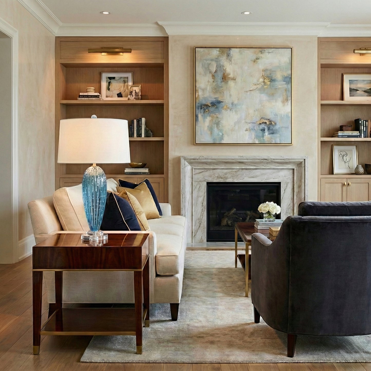 Living room with beige sofa, dark armchair, and a blue Murano glass lamp.