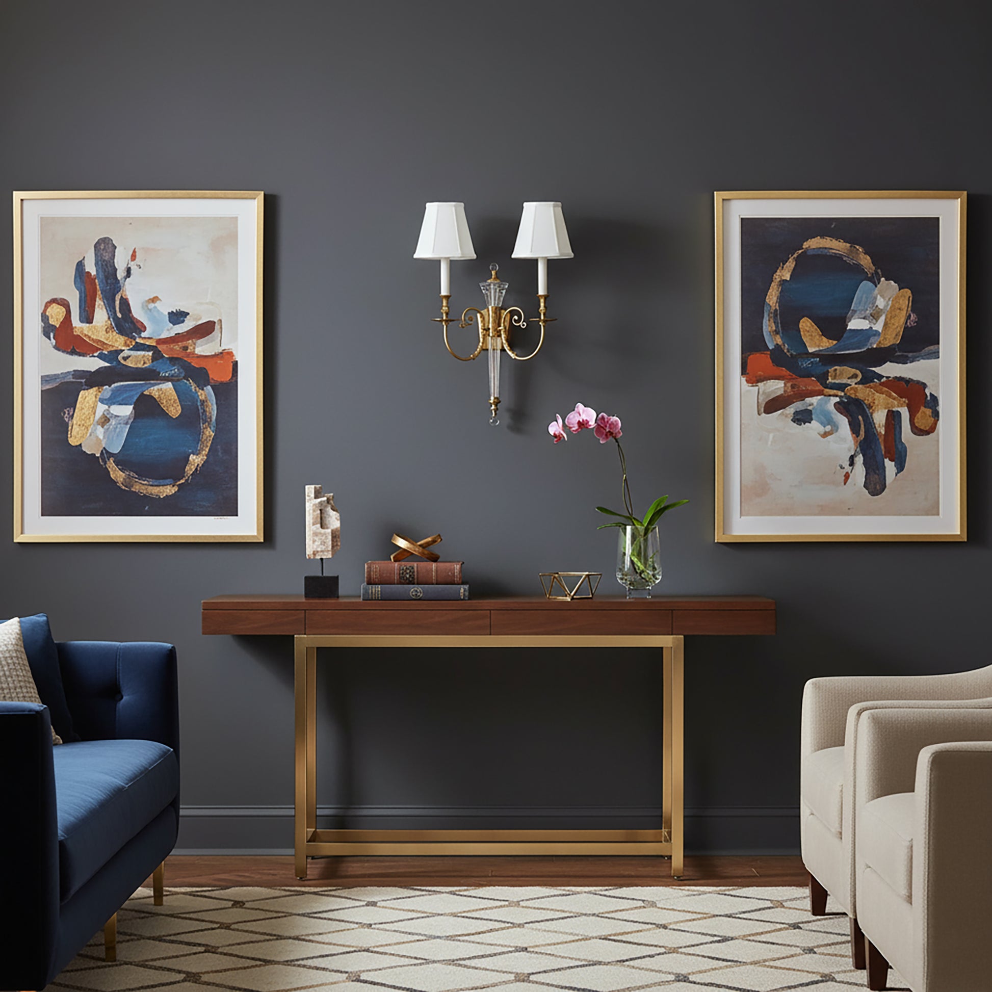 Living room with dark gray walls, a brass console table,  and a brass sconce.