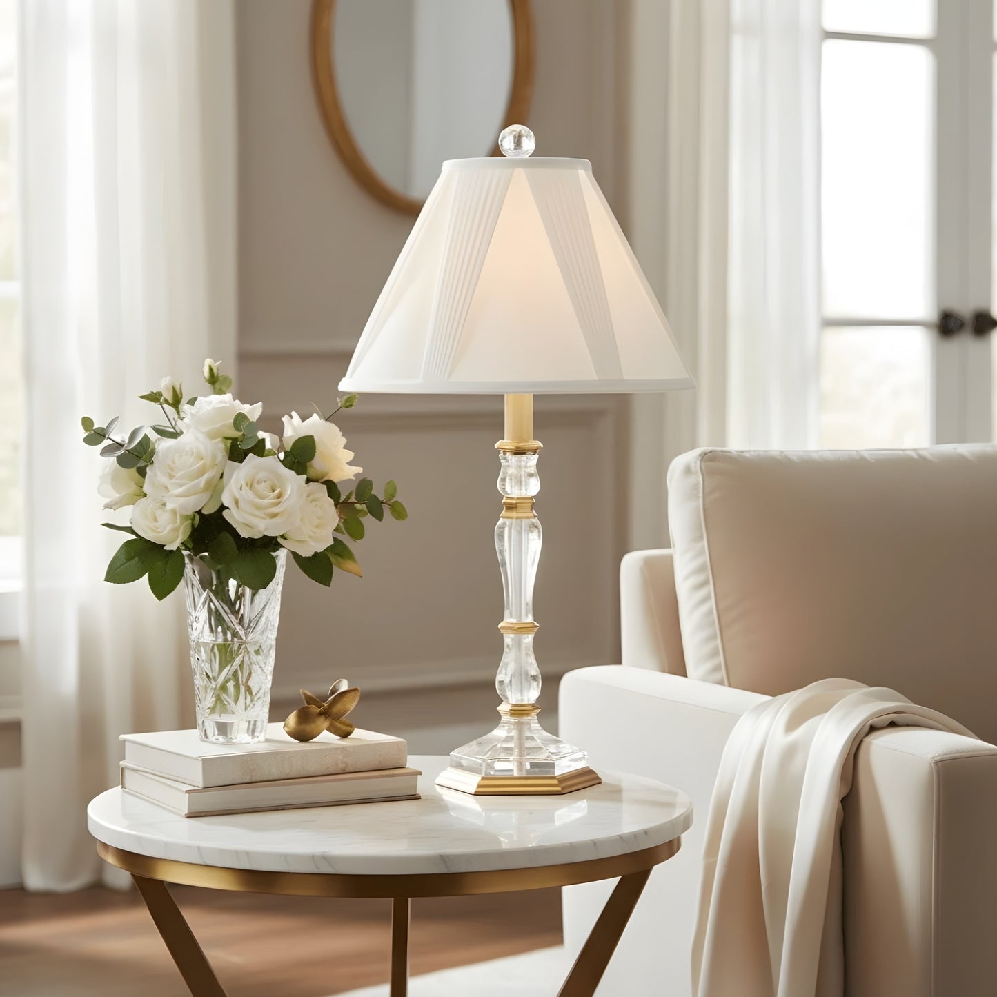 Decorative crystal and brass lamp on a marble table with flowers and books in a living room setting.