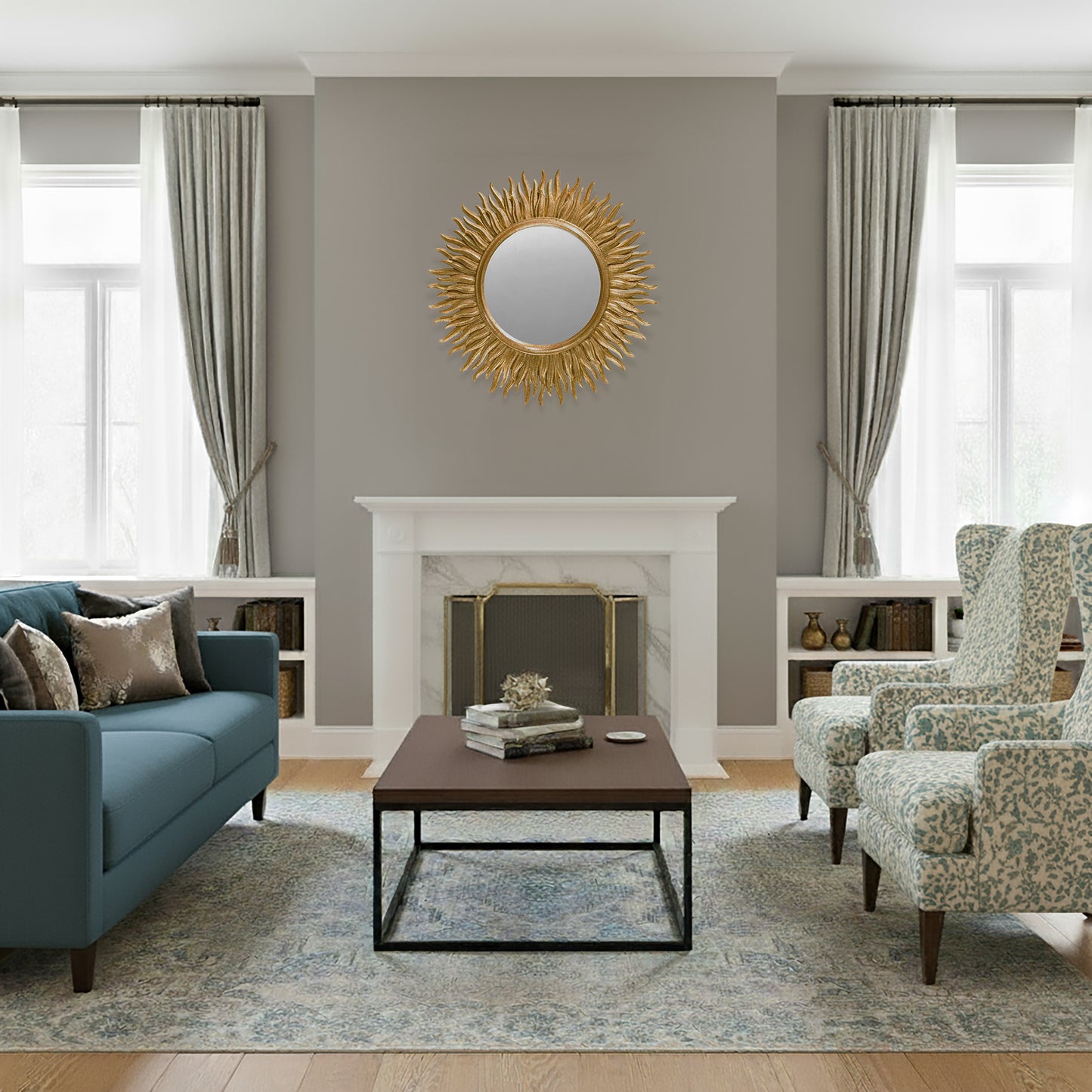 Living room with a brass fireplace screen, coffee table, and a gold mirror on a gray wall.