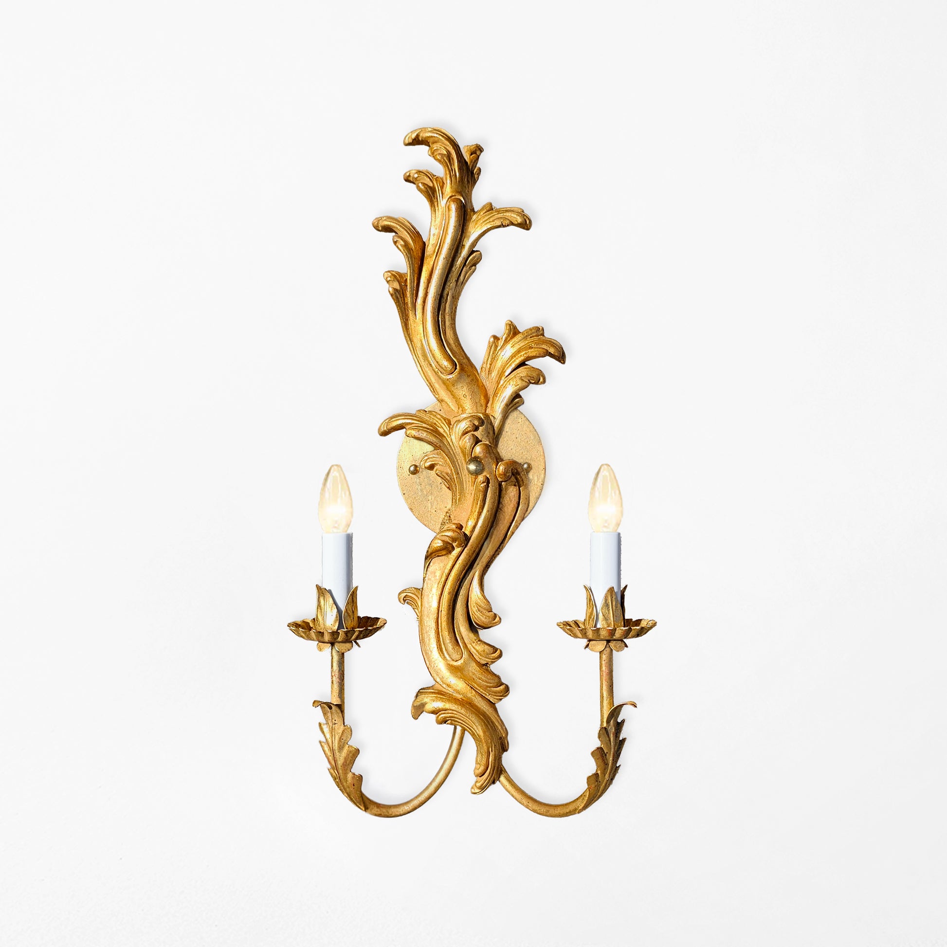 A handcarved solid wood gold leaf sconce.