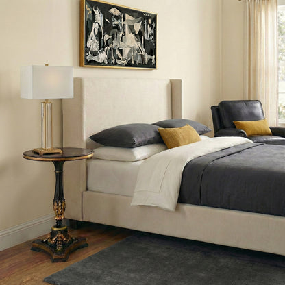 A bedroom with a handcarved gold-leaf end table.