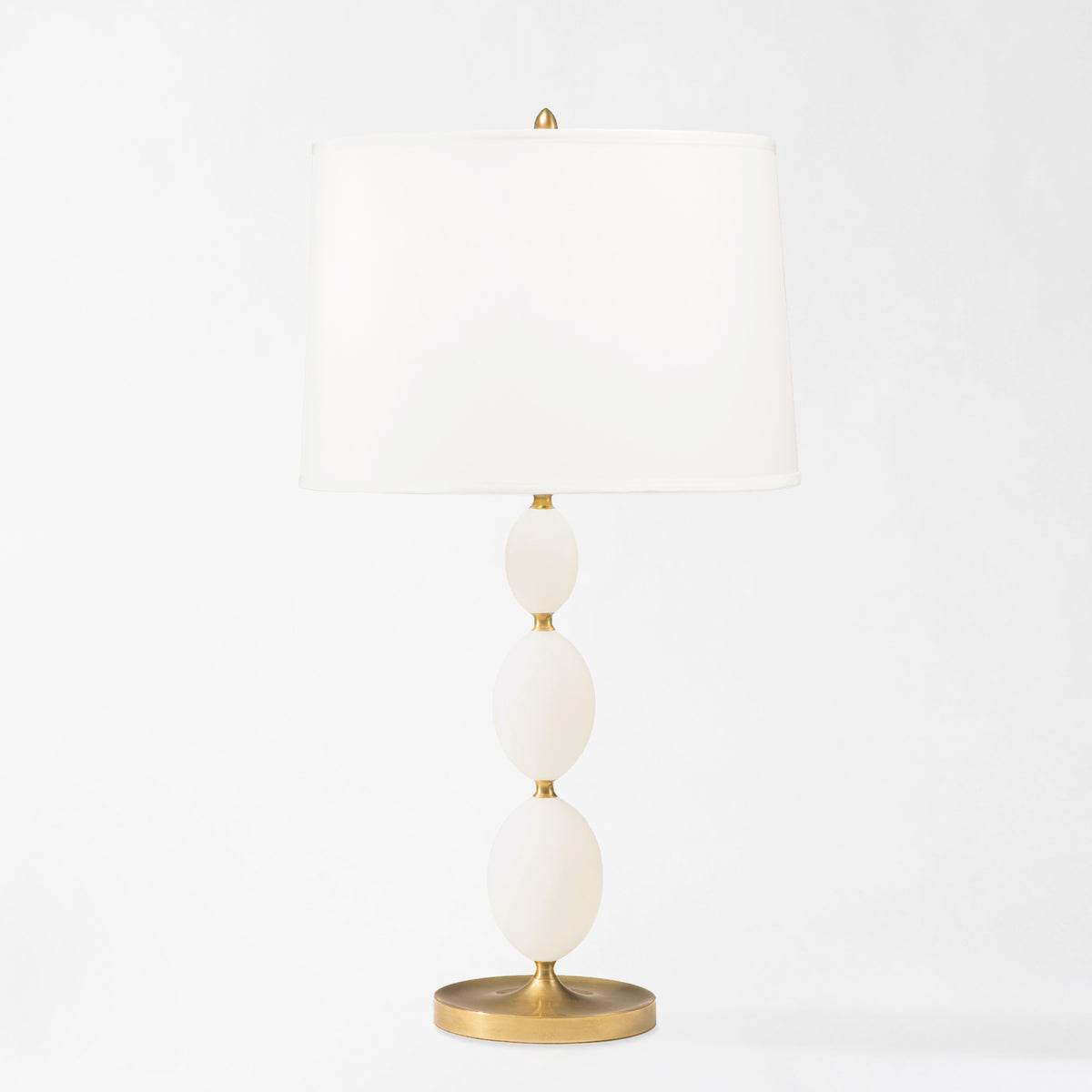 Antique brass and alabaster table lamp with white lamp shade.