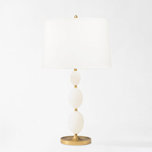 Antique brass and alabaster table lamp with white lamp shade.