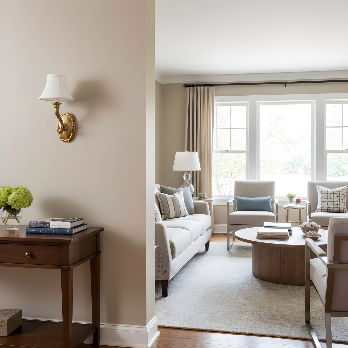 Living room with beige walls, brass sconce, and large windows.