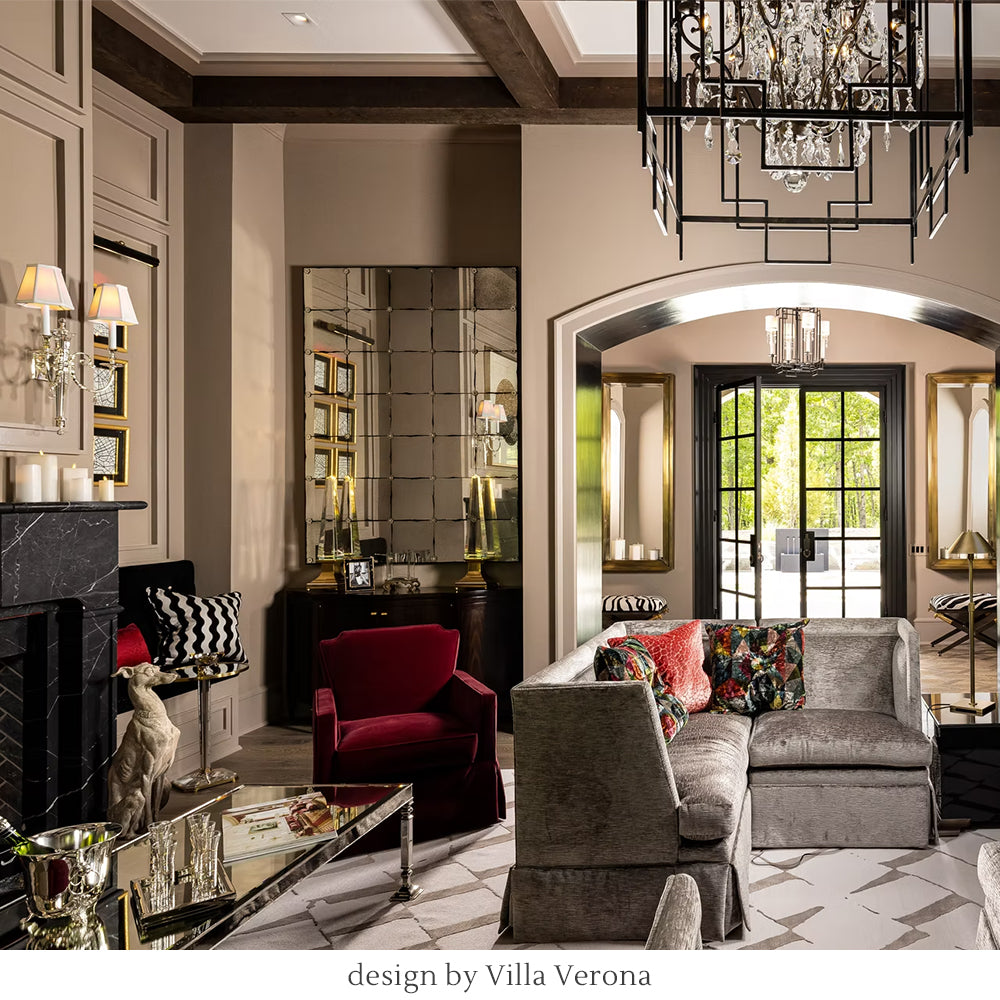 Luxurious living room with velvet sofa, red chair, decorative pillows, and crystal sconces. Designed by Villa Verona Interior Design.