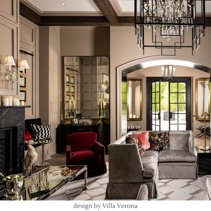 Luxurious living room with velvet sofa, red chair, decorative pillows, and crystal sconces. Designed by Villa Verona Interior Design.