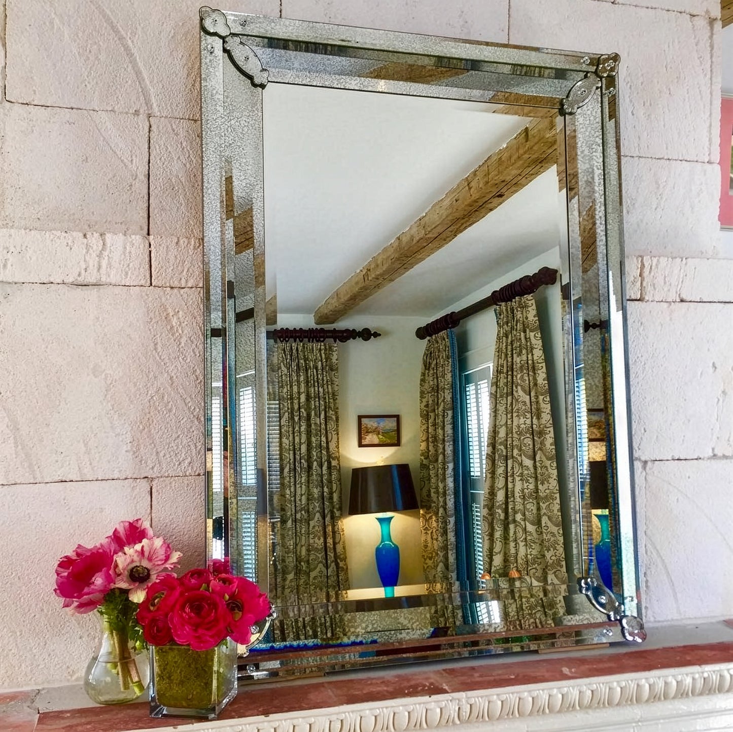 Rectangular Murano glass mirror above fireplace.