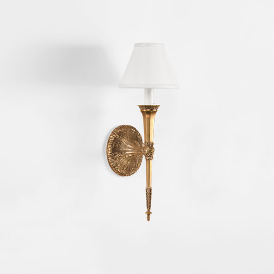 Luxurious brass sconce with white shade.