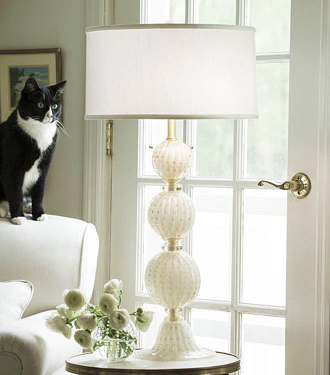 A white Murano glass lamp in a living room setting.