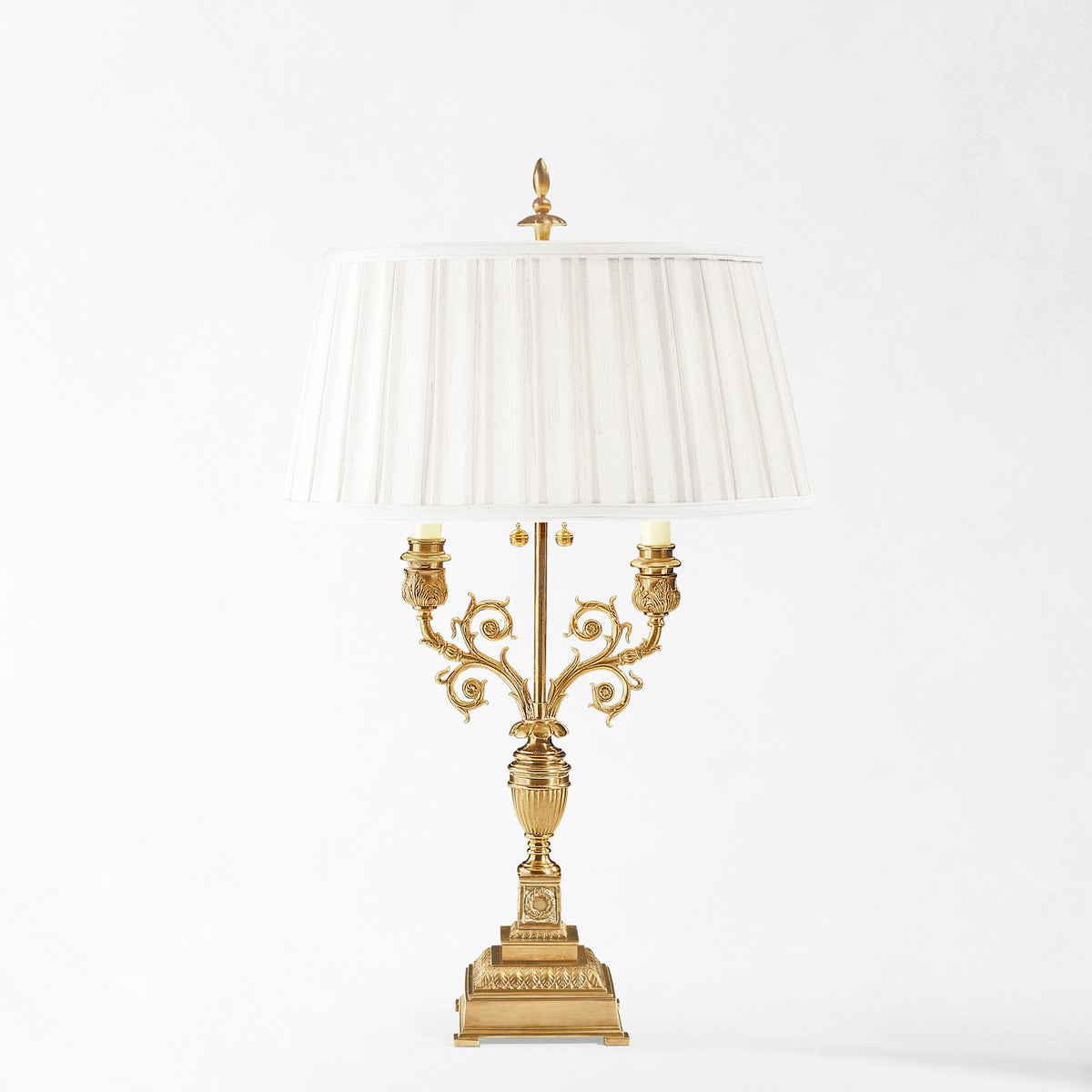 Antique brass table lamp with white pleated shade.