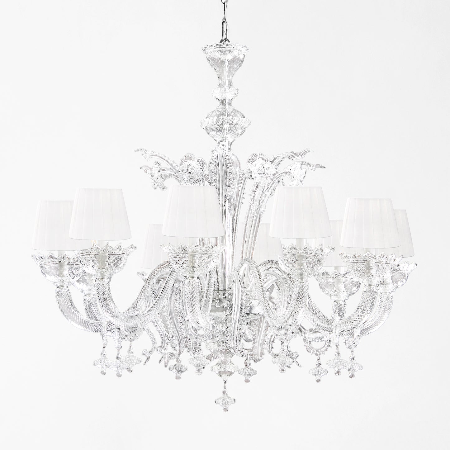 Luxurious Murano glass chandelier with clear glass and white pleated shades.