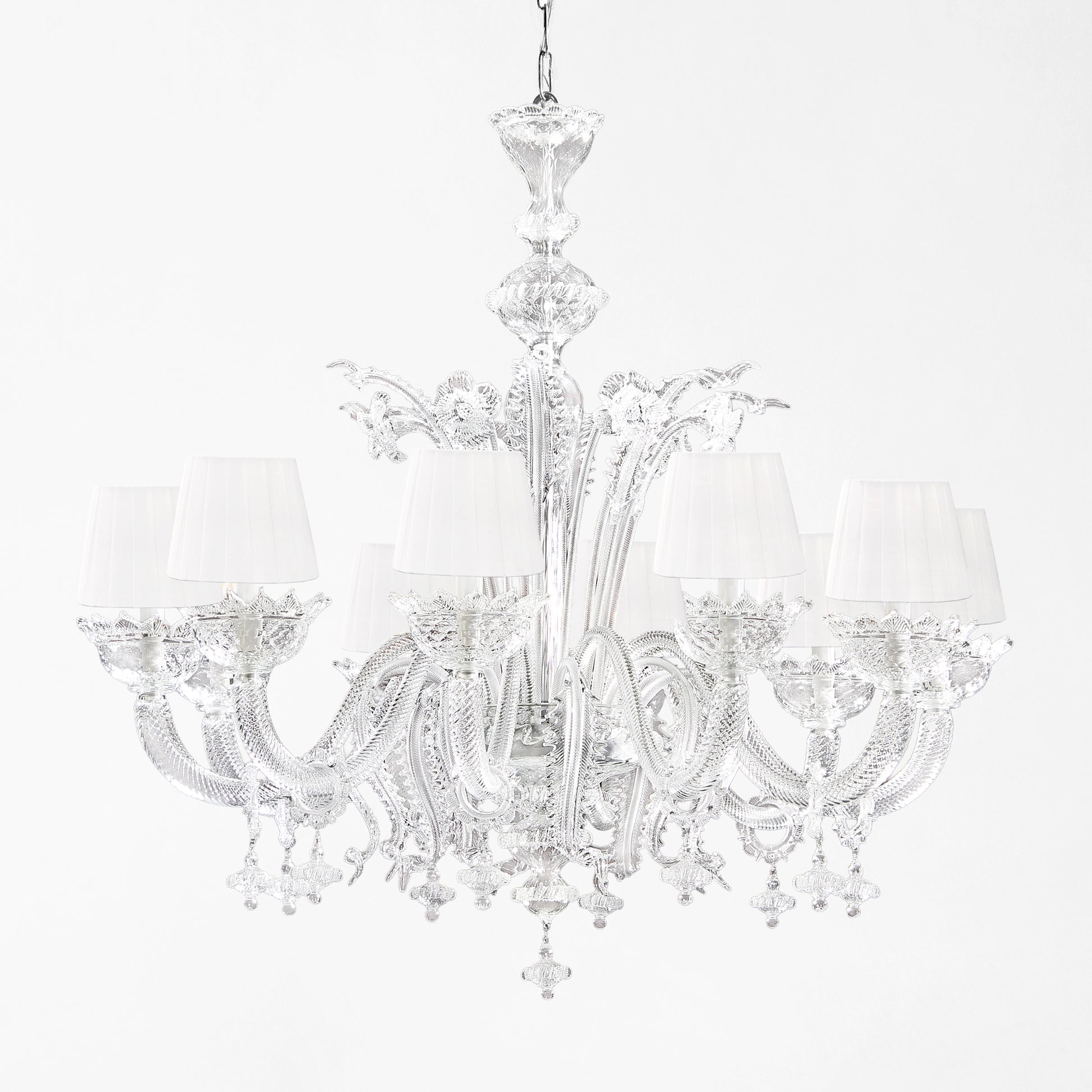 Luxurious Murano glass chandelier with clear glass and white pleated shades.