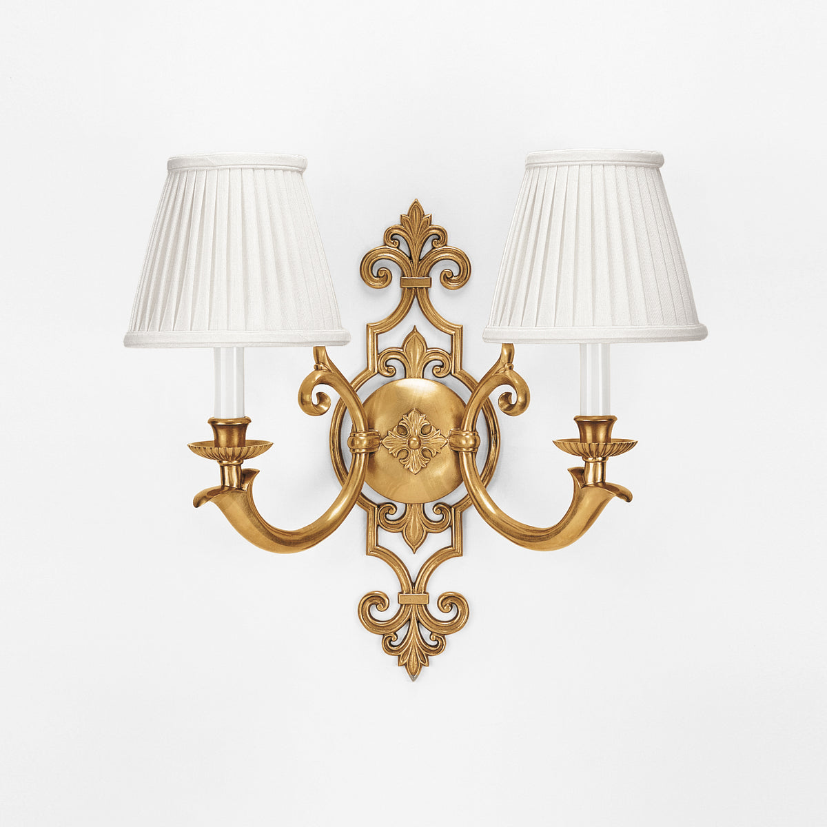 A luxury brass sconce with pleated white shades.