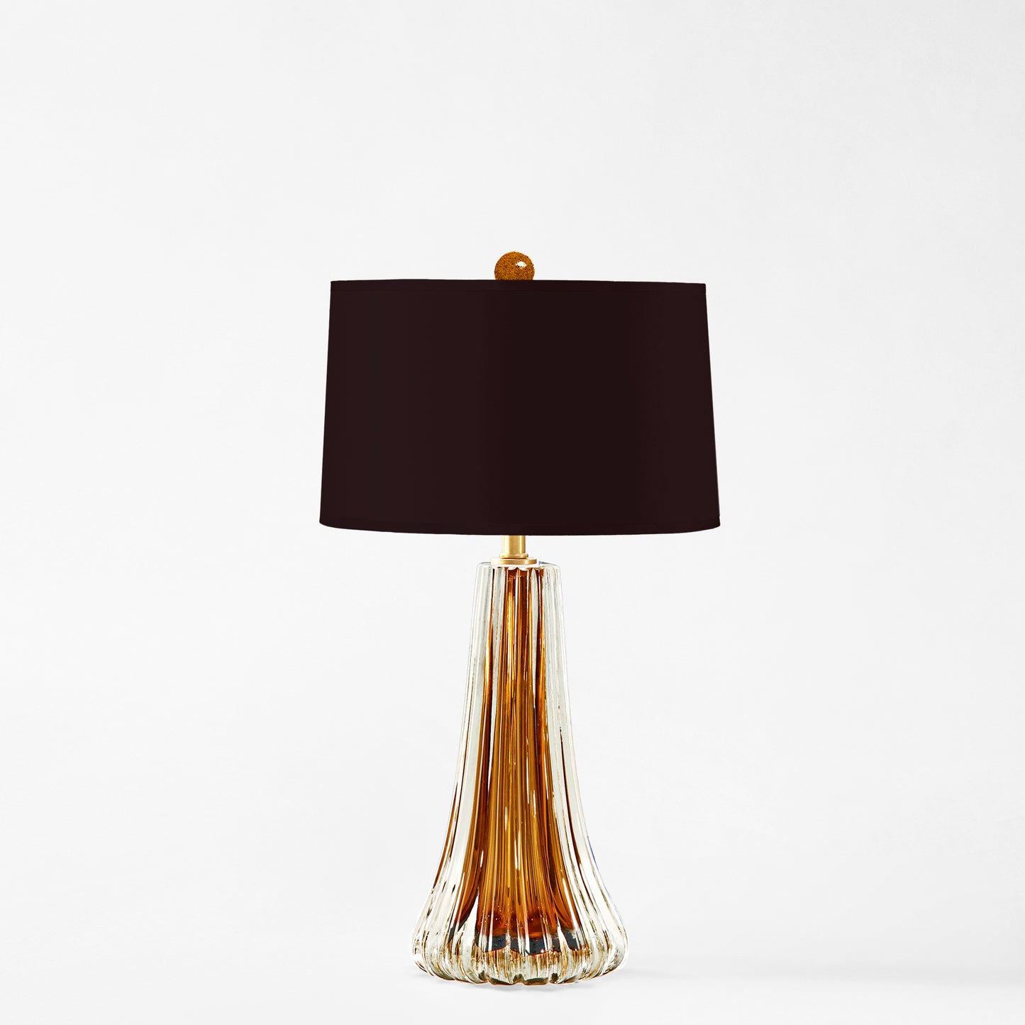 Amber Murano glass table lamp with black lamp shade.