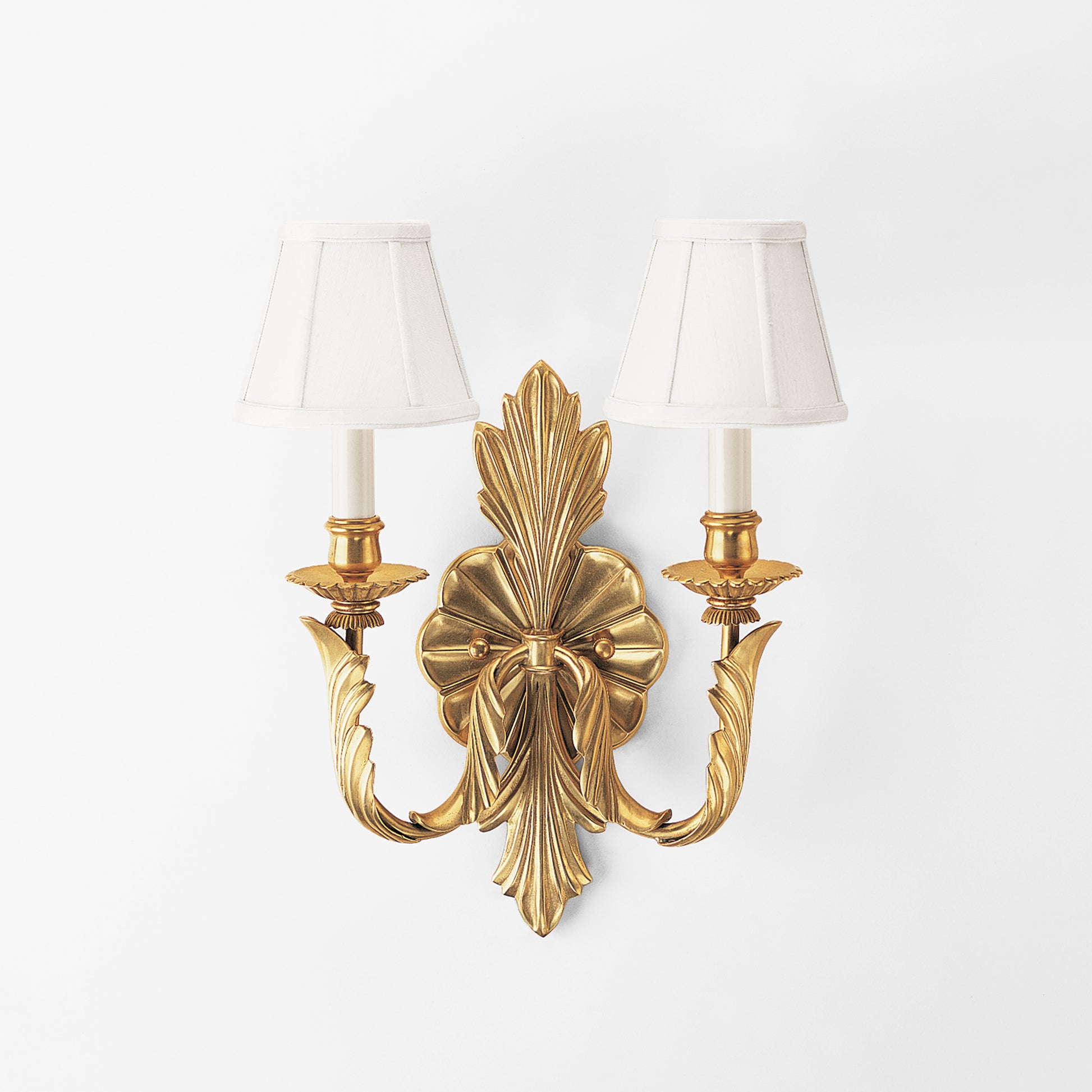 Antique brass sconce with white shades.