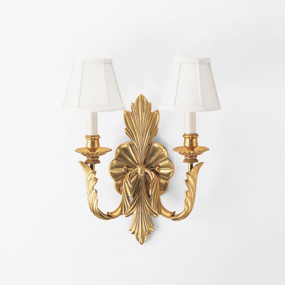 Antique brass sconce with white shades.