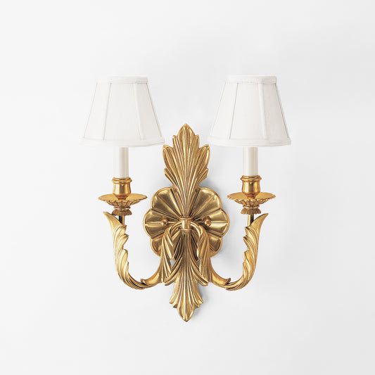 Antique brass sconce with white shades.