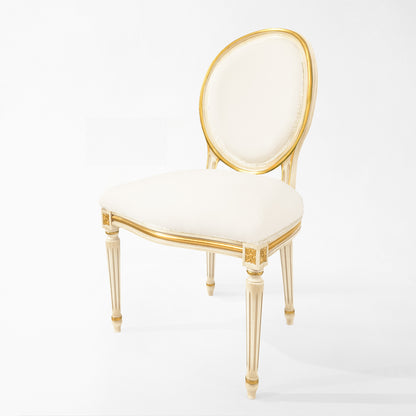 Antique white Italian chair with carved gold details and white fabric.