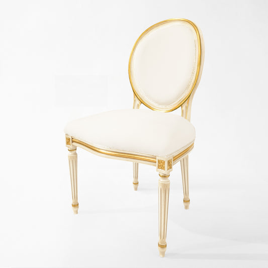 Antique white Italian chair with carved gold details and white fabric.
