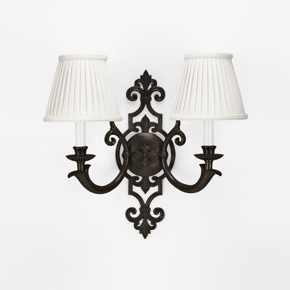 An antique brass sconce with a black finish.