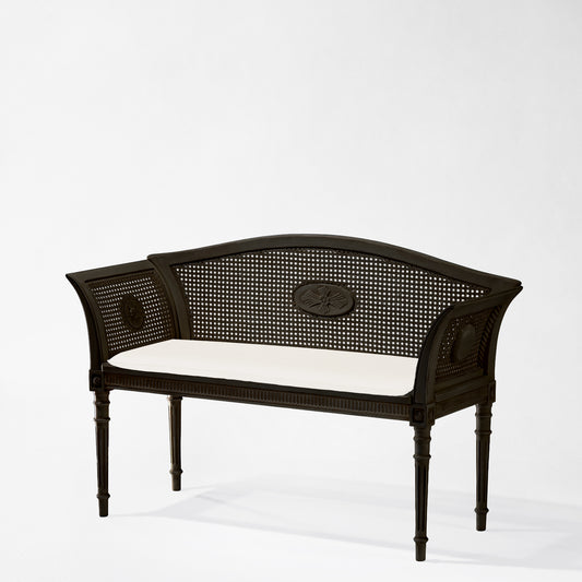 Italian black cane bench with white cushion.