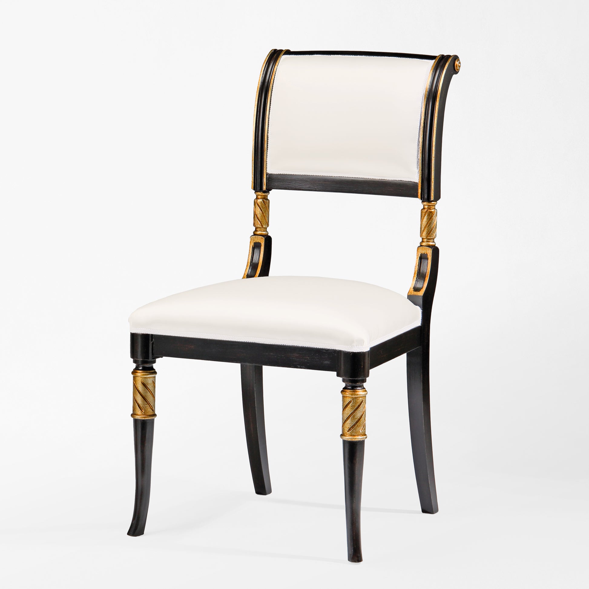 Black chair with gold details and white fabric.