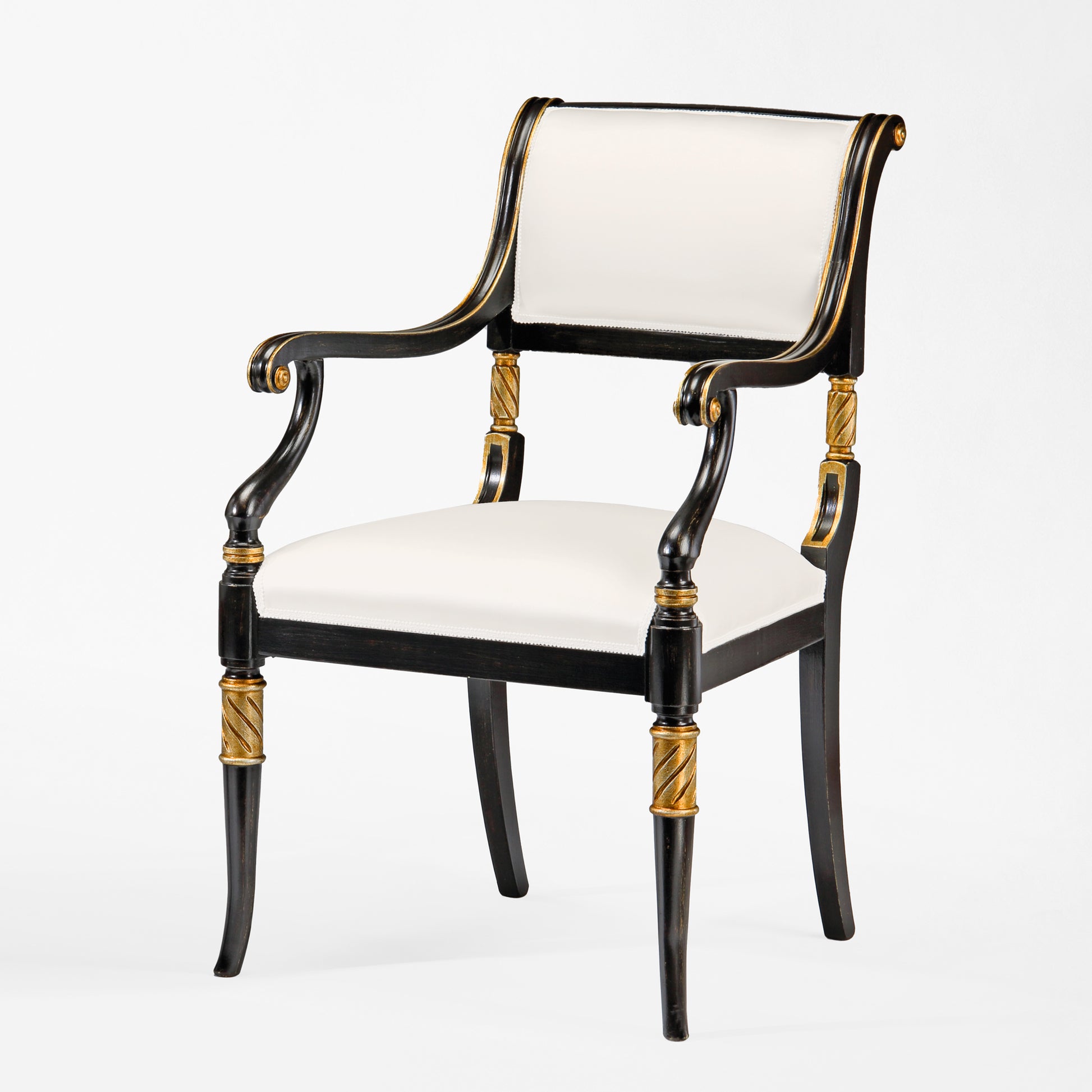 Black armchair with gold details and white fabric.