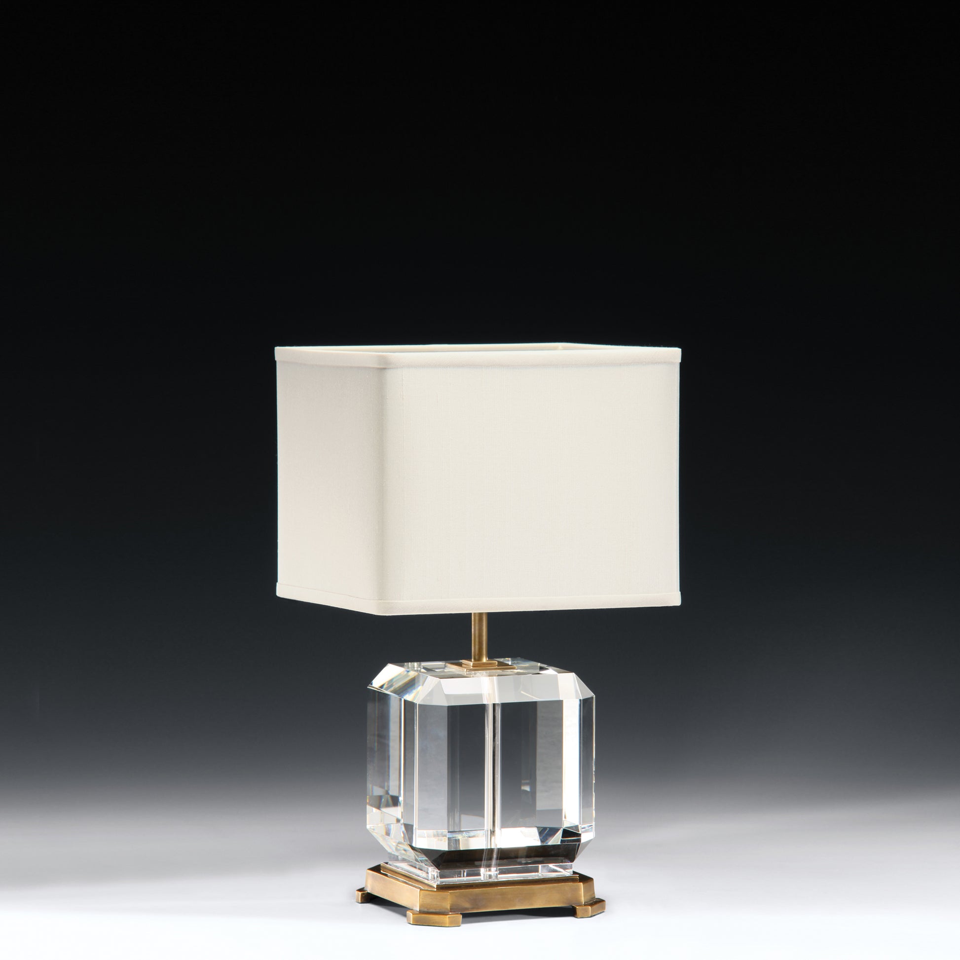 Short crystal table lamp with antique brass accent and modern square shade.