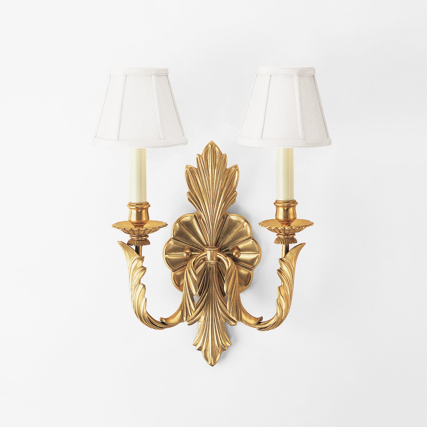Antique brass sconce with white shades.