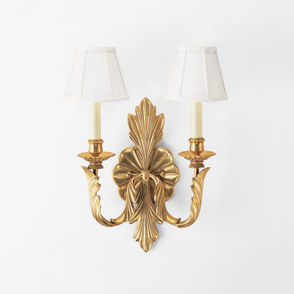 Antique brass sconce with white shades.