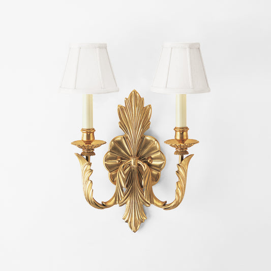 Antique brass sconce with white shades.