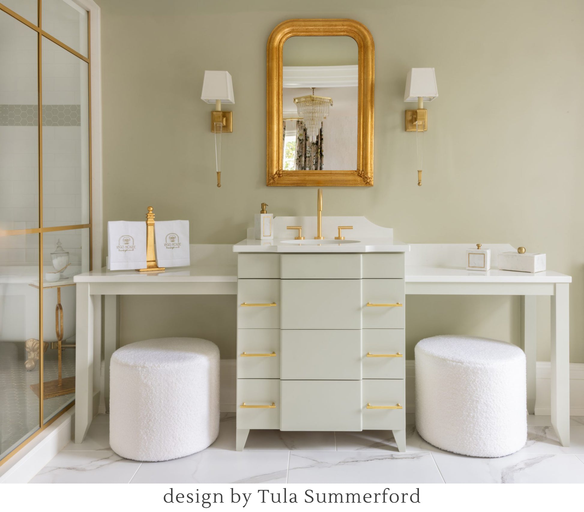 Brass sconces in luxurious bathroom with gold mirror.