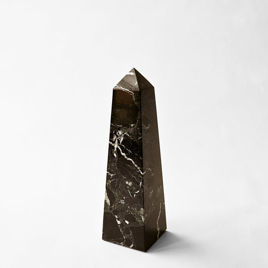 Dark brown marble obelisk.
