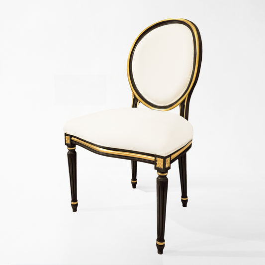 Carved wood Italian black chair with gold details and cream fabric.