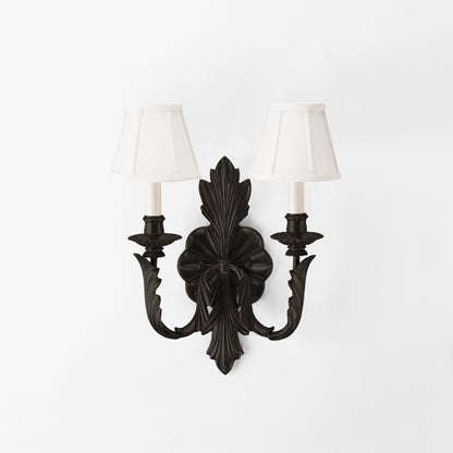 Traditional black, brass sconce with white lampshades.