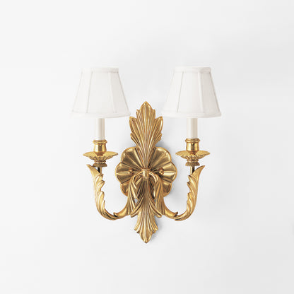 Luxurious brass sconce with white shades.