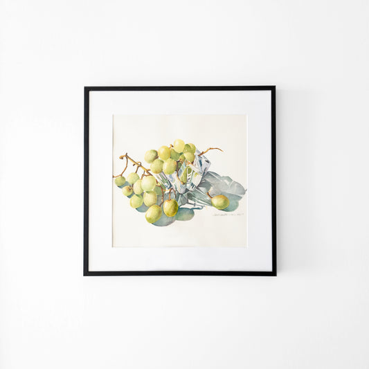 Watercolor painting of grapes in a crystal bowl in a back frame.