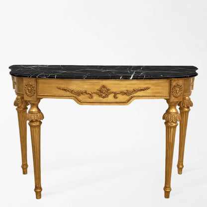 An Italian console table with a black marble top.