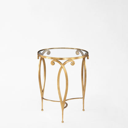Round gold side table with clear glass top.