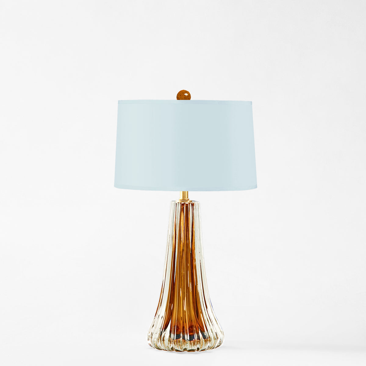 Amber Murano glass table lamp with light blue lamp shade.