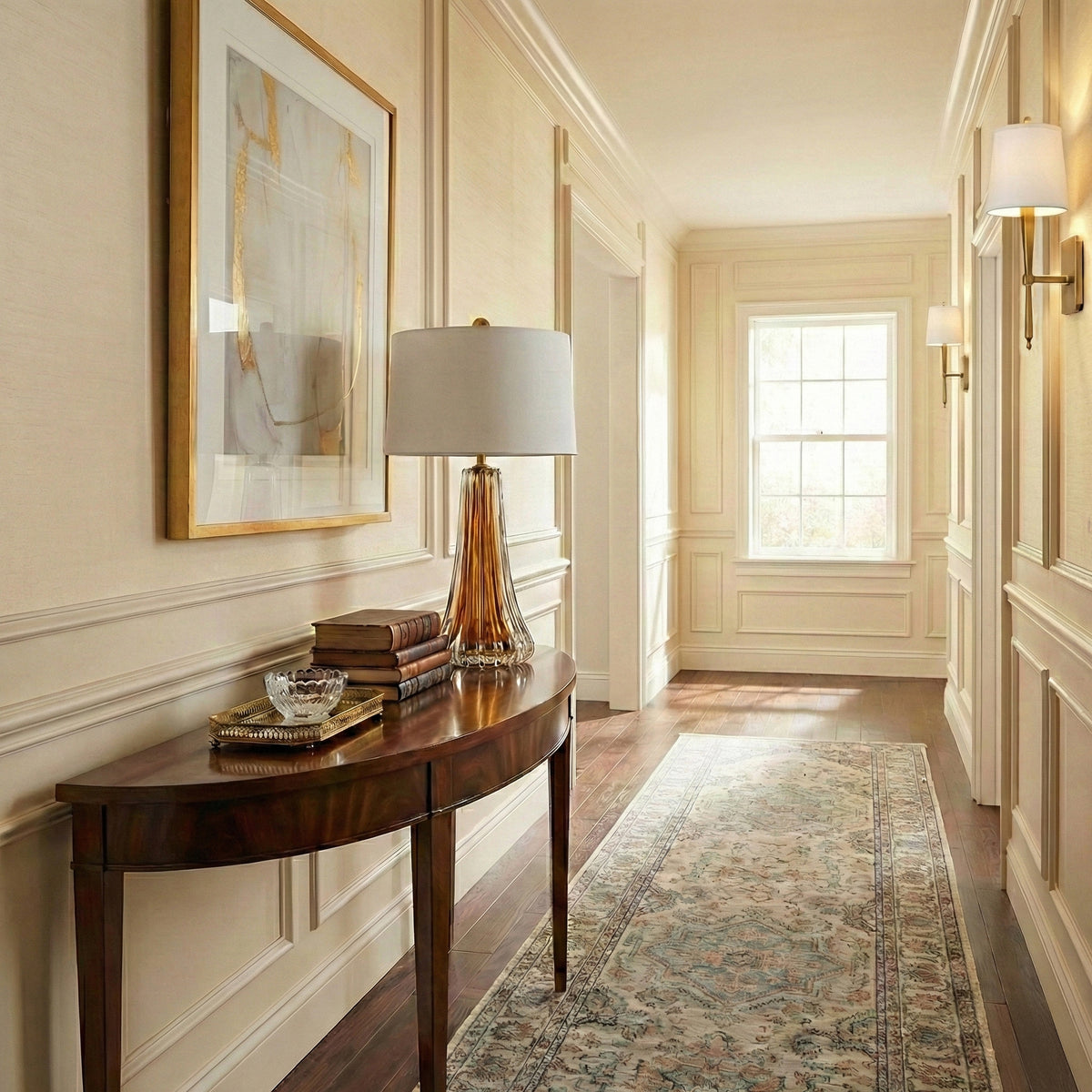 An amber Murano glass lamp with luxurious brass sconces in an elegant hallway.