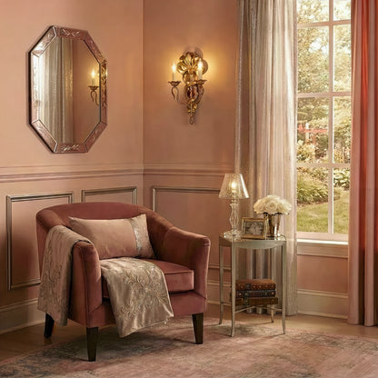 Italian luxury sconce with pink Venetian glass mirror and pink velvet chair in elegant living room.