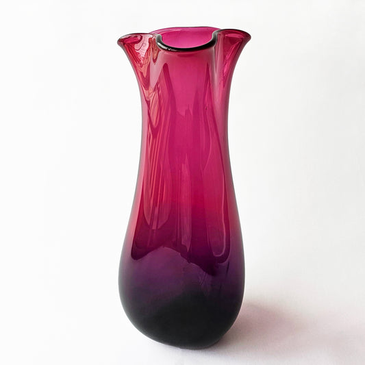 Magenta glass vase with modern design.